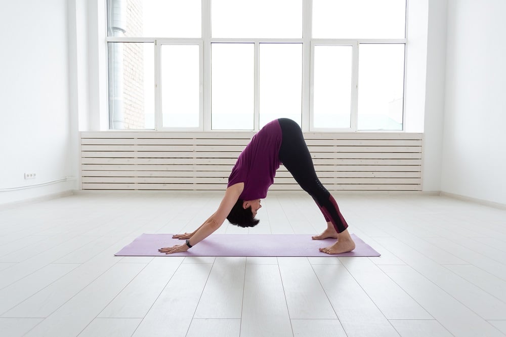 Yoga, conceito de pessoas - uma mulher de meia-idade fazendo ioga e tenta fazer um asana